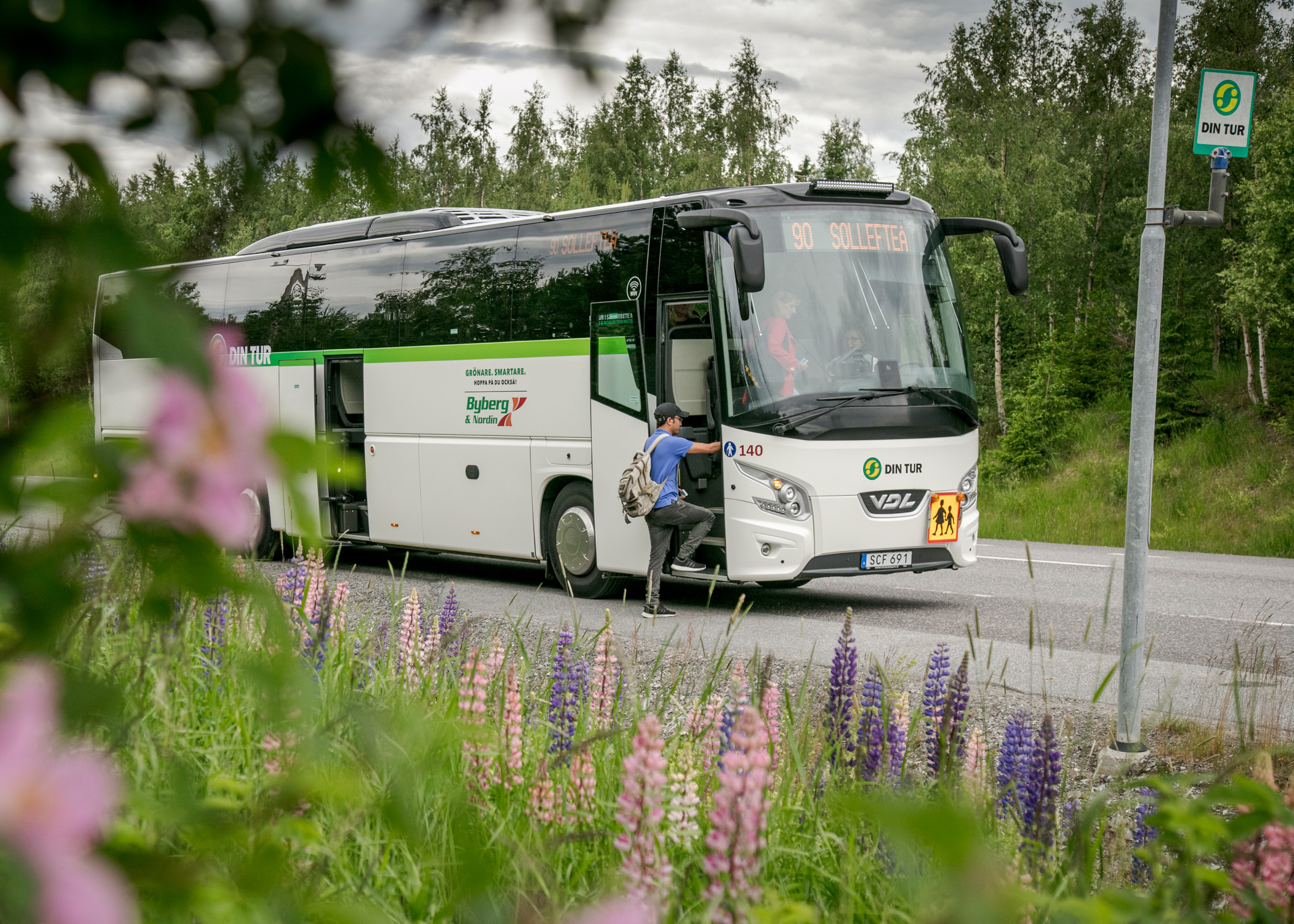 Bild på en landsbygdsbuss vid en hållplats.