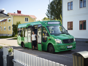 grön liten buss med kvinna som kliver ur